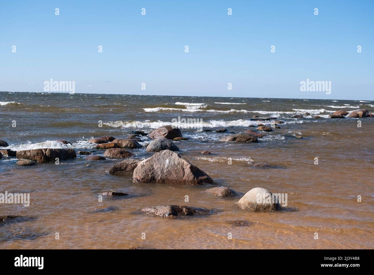 Mar Baltico, Golfo di riga, rocce in acqua, primavera. Onda spruzzando sopra le rocce. Foto Stock