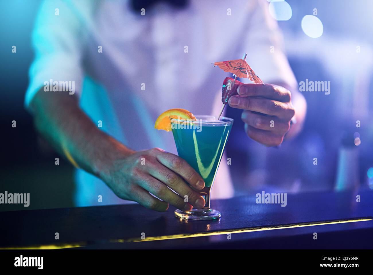 La bevanda perfetta per le feste mescolata solo per te. Un barman che serve un cocktail appena fatto in un bar. Foto Stock