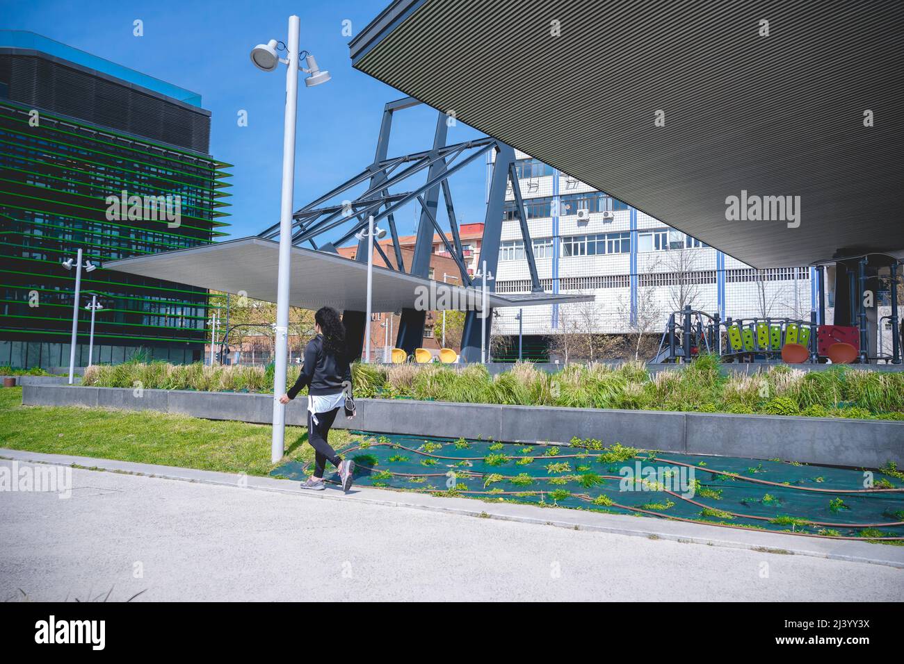 Bilbao, San Ignacio, Spagna - 09, Aprile, 2022: Nuova passeggiata dell'estuario di Bilbao. Donna che fa sport mentre ascolta la musica con il suo telefono cellulare, Foto Stock