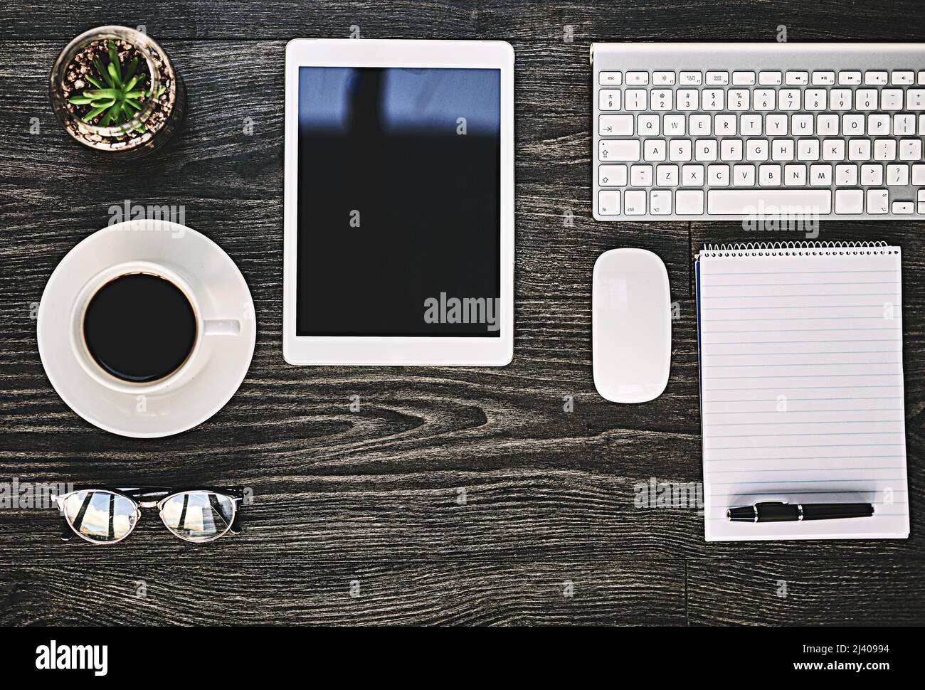 Dove avviene la produttività. Scatto ad angolo elevato di una vasta gamma di dispositivi wireless su una scrivania. Foto Stock