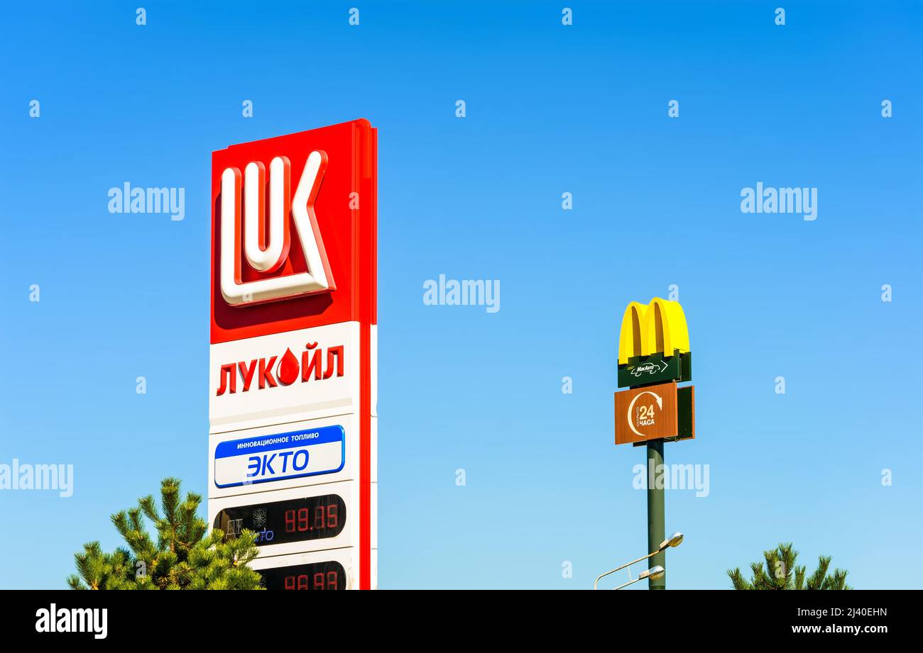Russia, 2021: Segnaletica stradale della stazione di benzina Lukoil e McDonalds McAuto, 24 ore di servizio auto Foto Stock