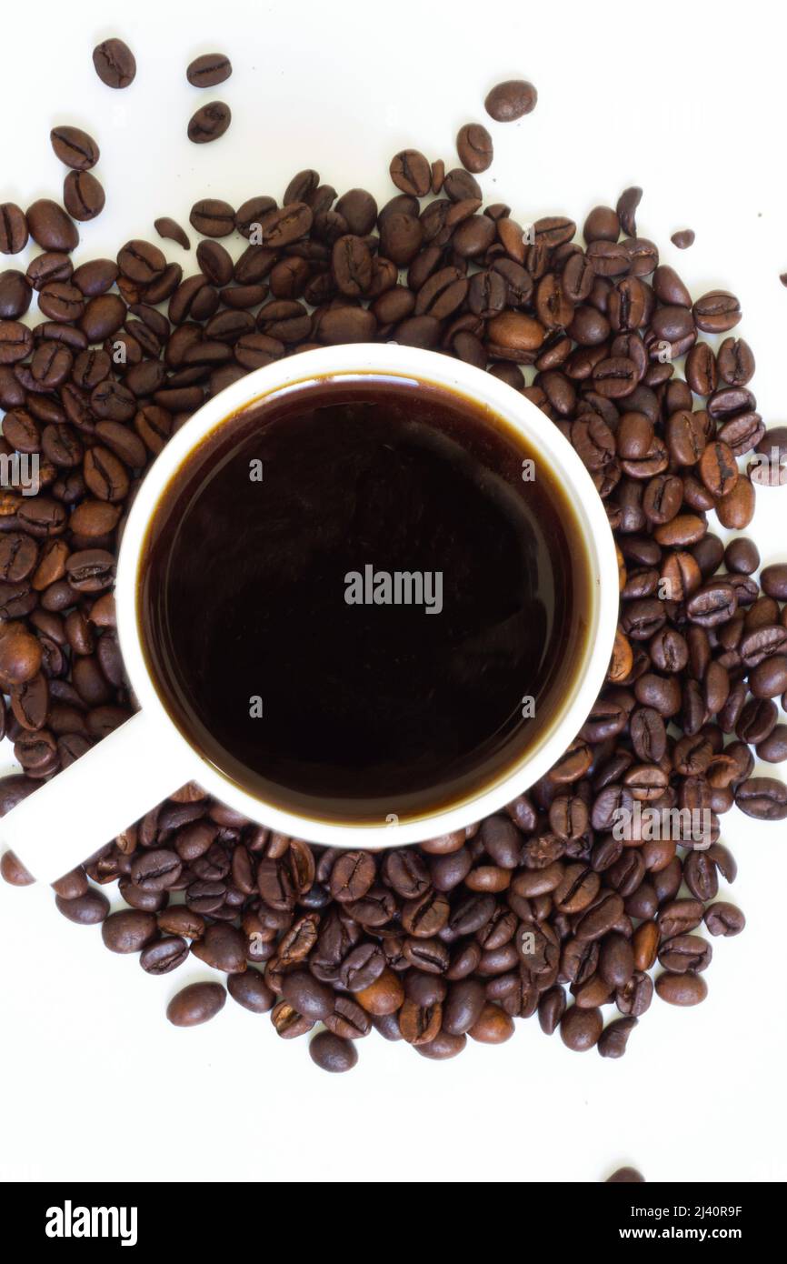 Caffè macinato in grani e caffè caldo appena fatto nella tazza Foto Stock