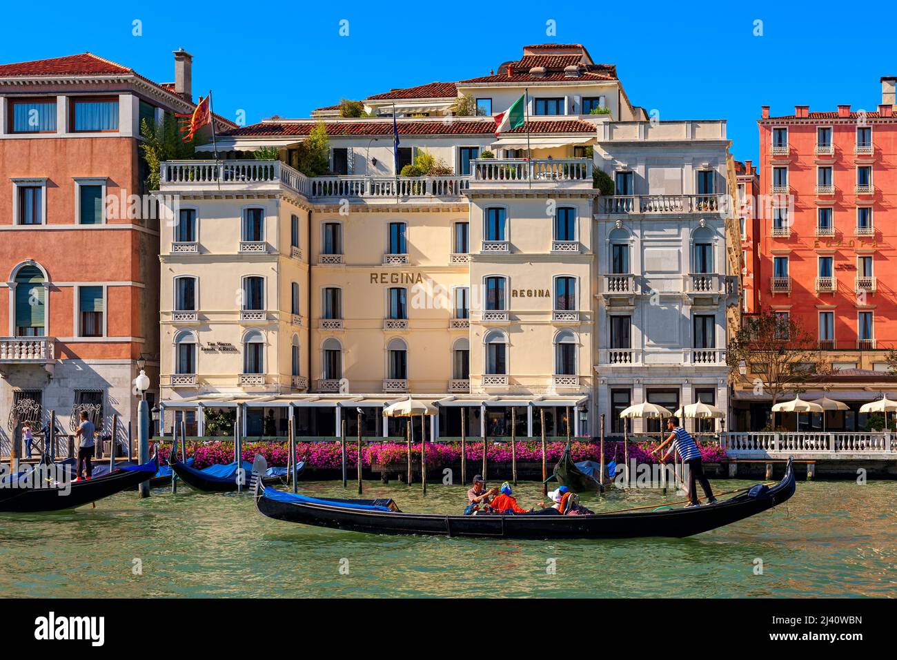 Gondola sul Canal Grande passando da tipici edifici colorati e Hotel Regina a Venezia, Italia. Foto Stock