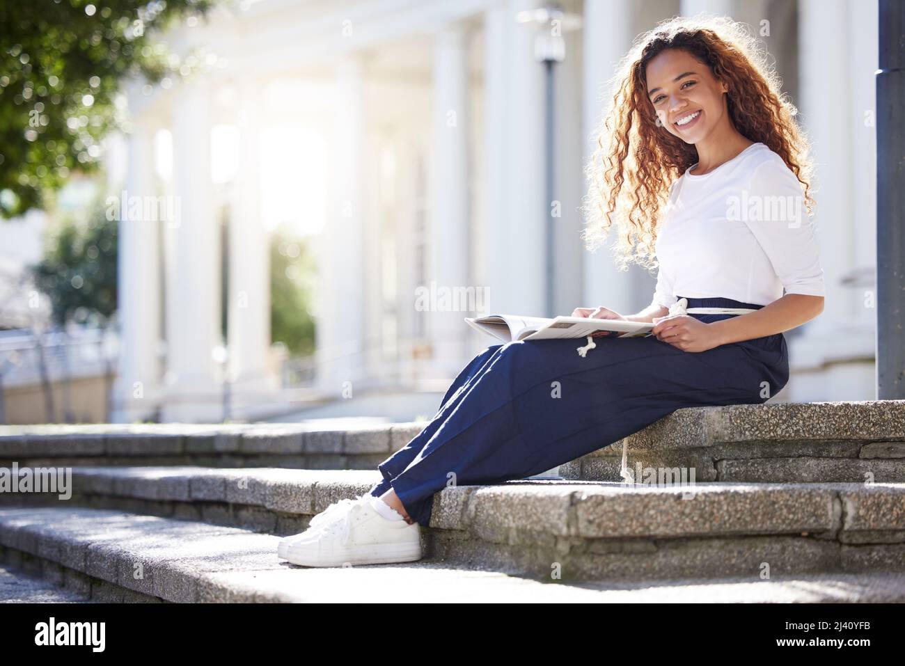La salute e la felicità sono una combinazione impossibile. Scatto di una giovane donna che legge un libro fuori dal campus. Foto Stock