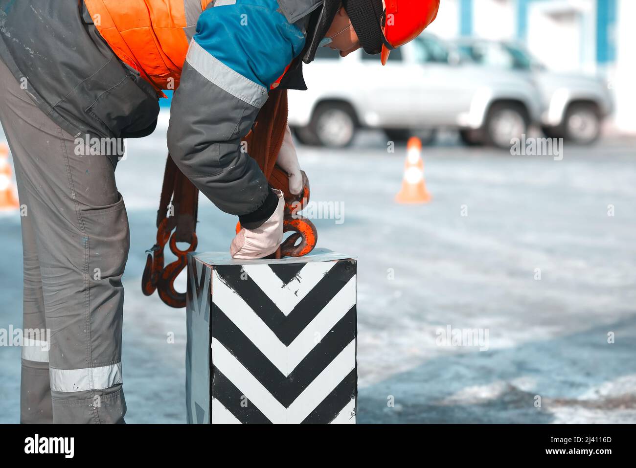 I ganci degli indumenti da lavoro con la molla controllano il carico con il gancio. Autentico lavoro di scena alla base di produzione sulla strada del giorno d'inverno. Formazione ed educazione di slingers. Foto Stock