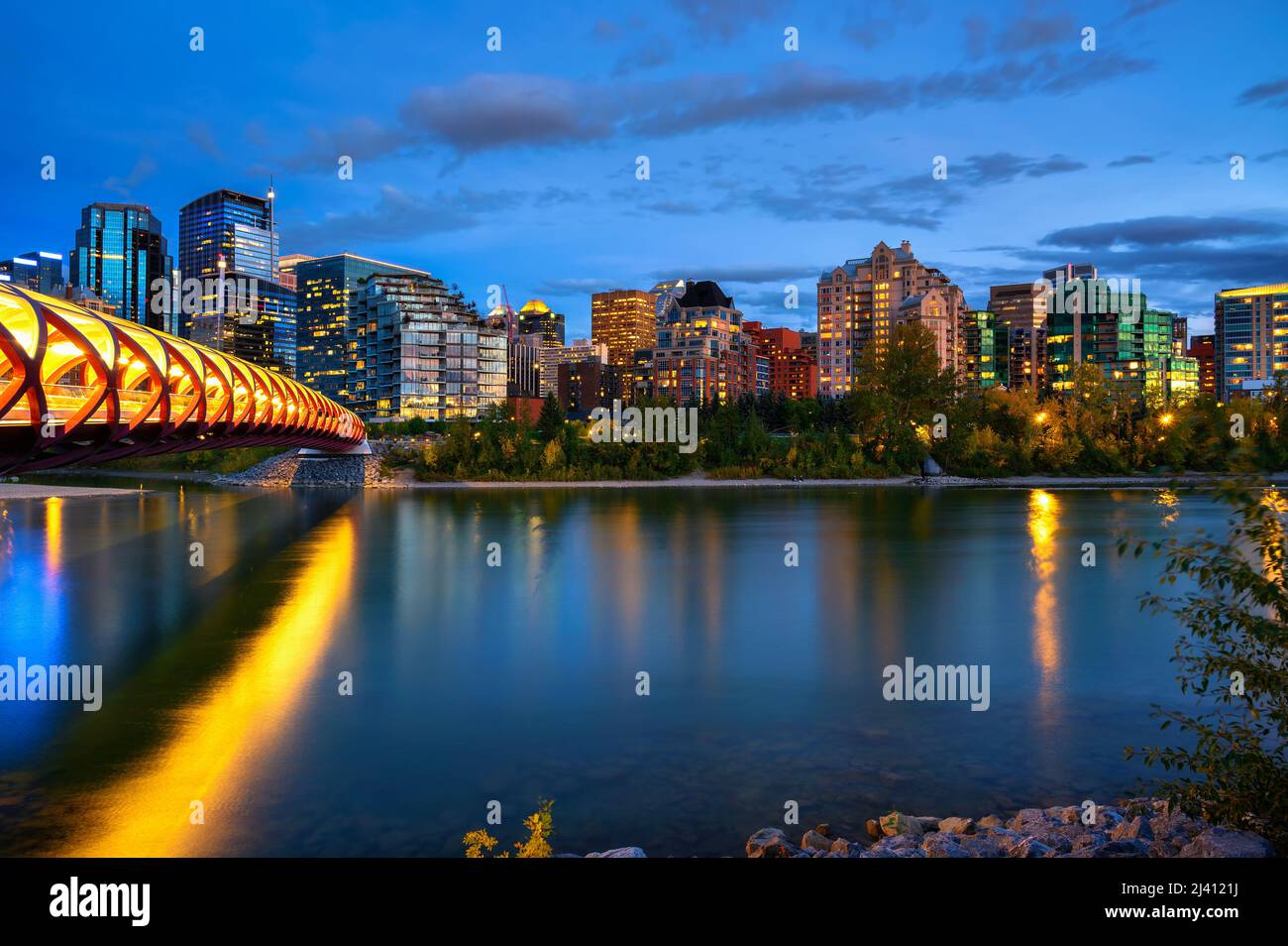 Peace Bridge attraverso il fiume Bow e lo skyline di Calgary fotografato di notte Foto Stock