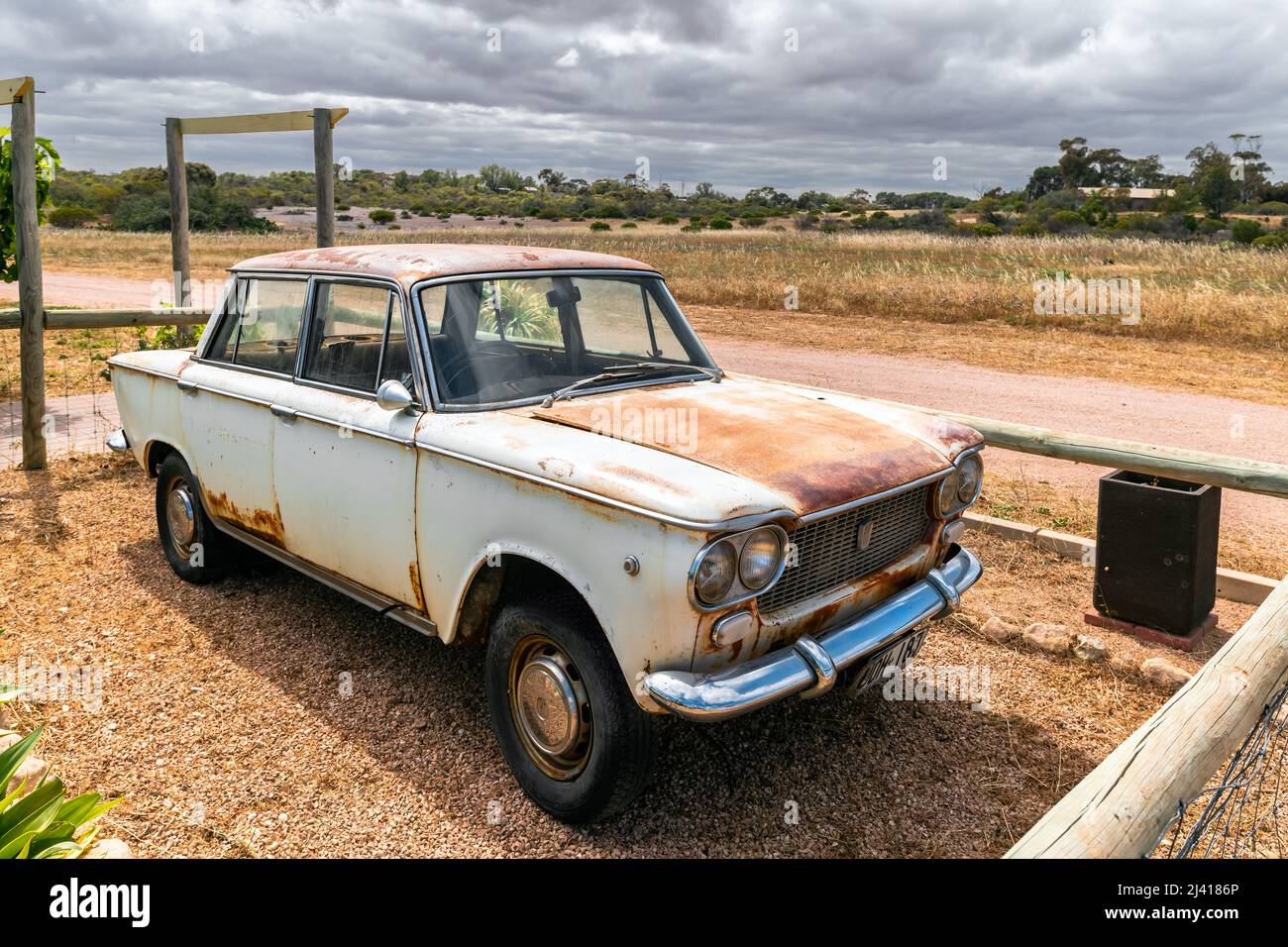 Moonta, South Australia - 27 ottobre 2019: Vecchia Fiat 1500 arrugginita parcheggiata vicino alla fattoria in Outback australiano in una giornata intensa Foto Stock