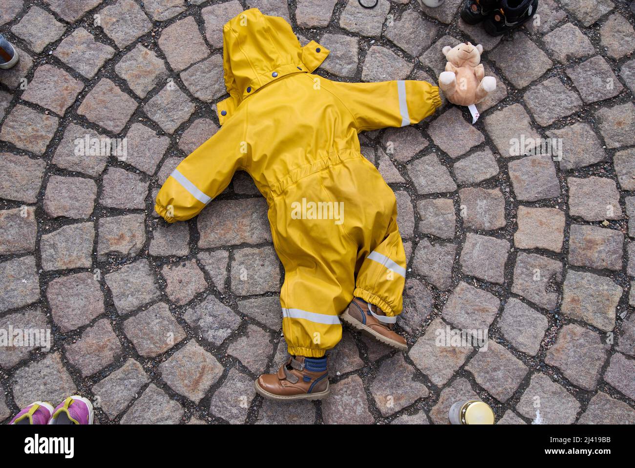 Helsinki, Finlandia - 10 aprile 2022: Tute e scarpe per bambini di colore giallo ritorto nella manifestazione “Mariupol: Crimini di guerra russi” organizzata dall’Ucraina Foto Stock