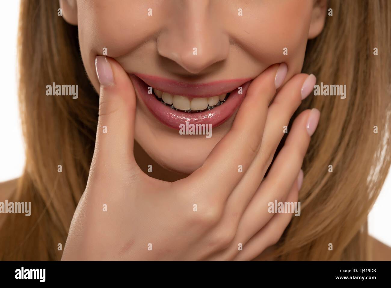 ritratto corto di giovane donna che allunga la bocca in falso sorriso con le dita Foto Stock