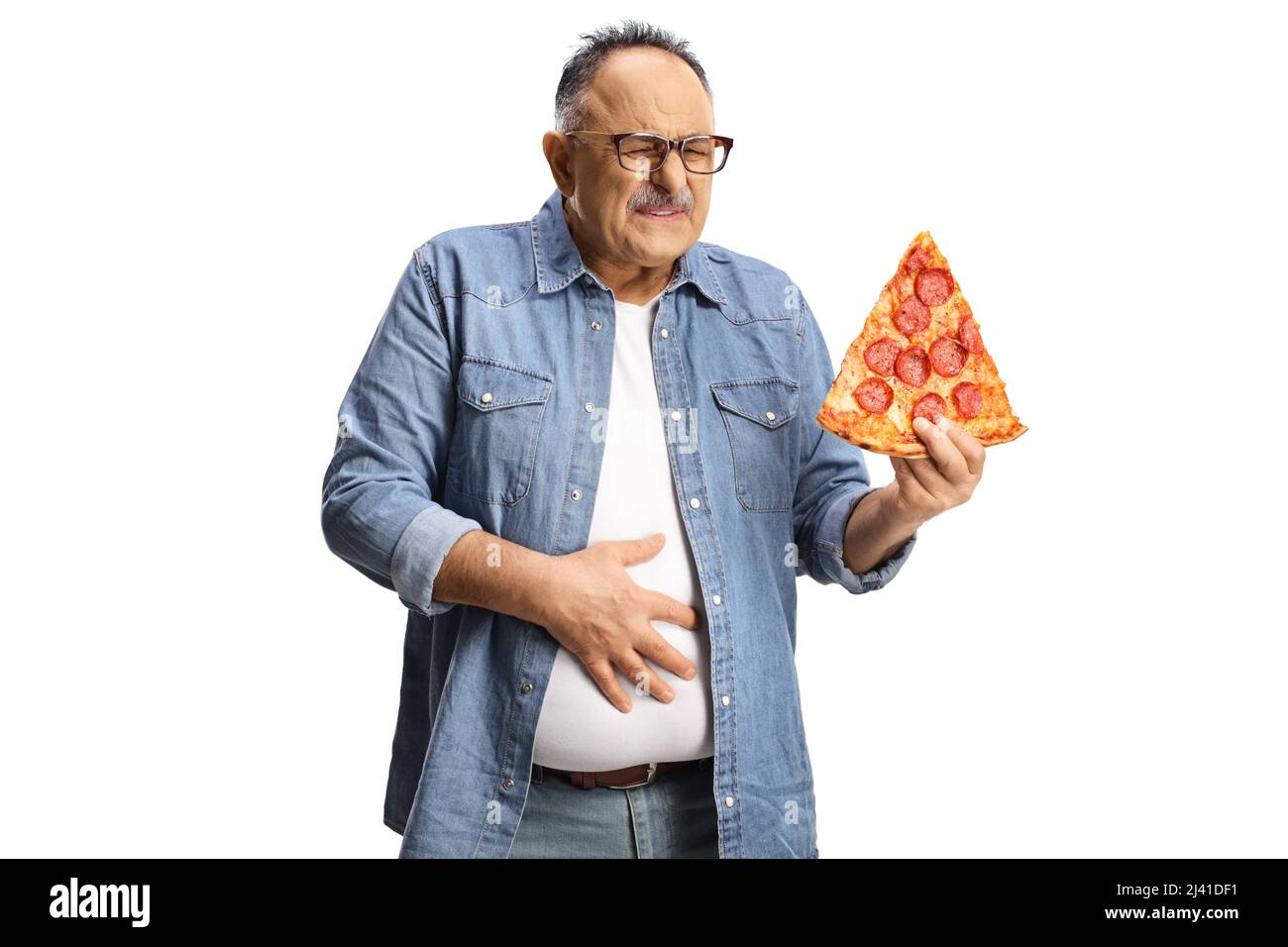 Uomo maturo che tiene una fetta di pizza pepperoni e tiene il suo addome in dolore isolato su sfondo bianco Foto Stock