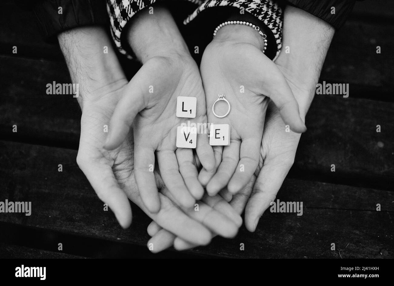 fidanzamento coppie a coppe mani con anello e scrabble pezzi ortografia amore Foto Stock
