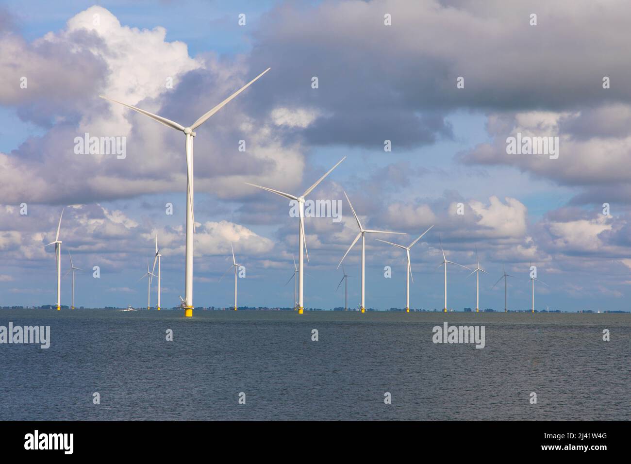 Vista aerea di enormi mulini a vento si trova sul mare lungo un mare olandese. Fryslân Wind Farm, la più grande fattoria eolica interna del mondo. Afsluitdiijk Foto Stock