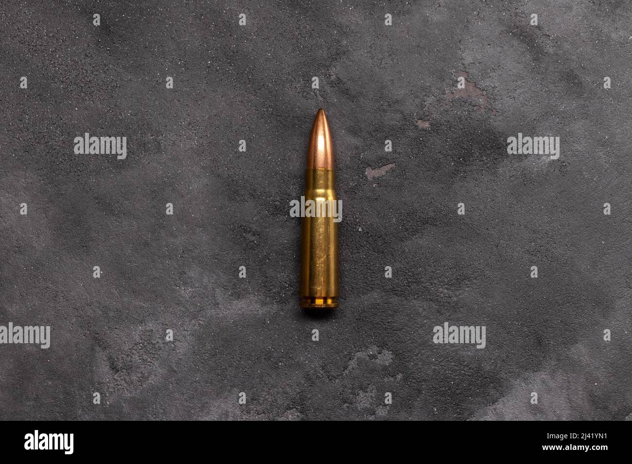 Pallottola su sfondo grigio. Cartuccia 7,62 calibro per fucile d'assalto Kalashnikov Foto Stock