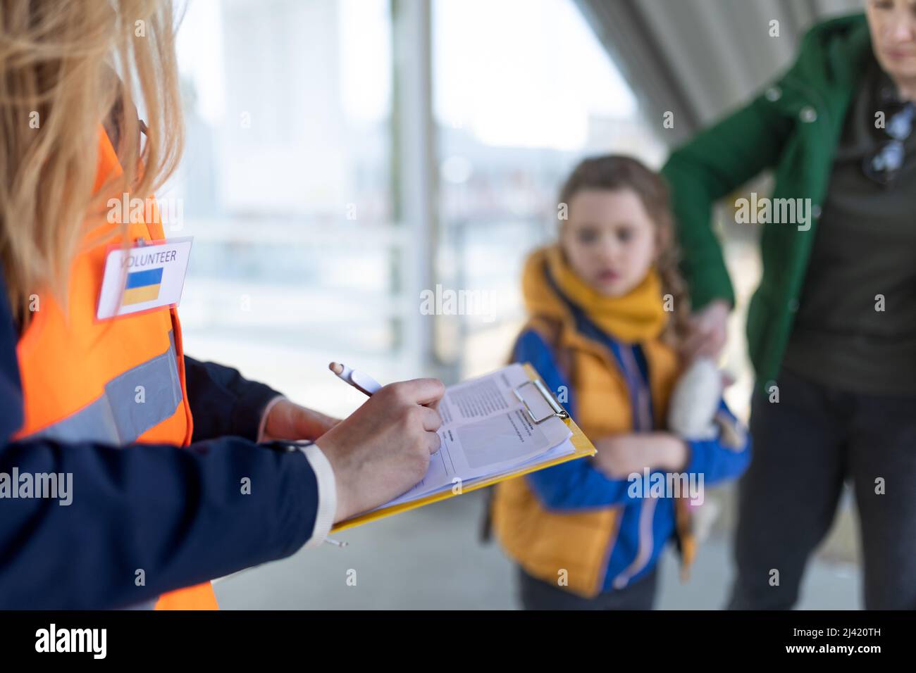 Volontario che registra i rifugiati ucraini alla stazione ferroviaria. Foto Stock