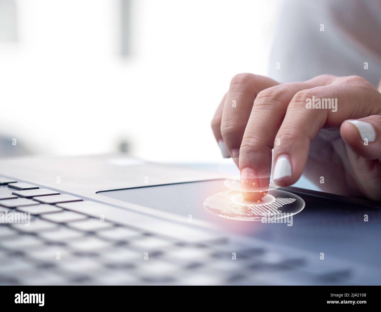 Collegare la tecnologia del mondo del futuro. Icone digitali della terra da primo piano toccate da un elegante dito donna sul touchpad di un computer portatile, il business glob Foto Stock