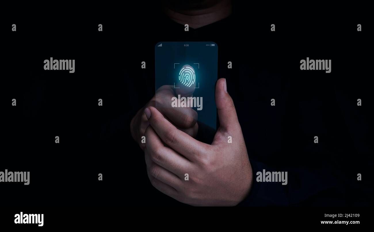L'icona di scansione delle dita è apparsa mentre il dito dell'uomo è toccato sul futuristico telefono cellulare in vetro trasparente su sfondo scuro. Sicurezza informatica, data prote Foto Stock