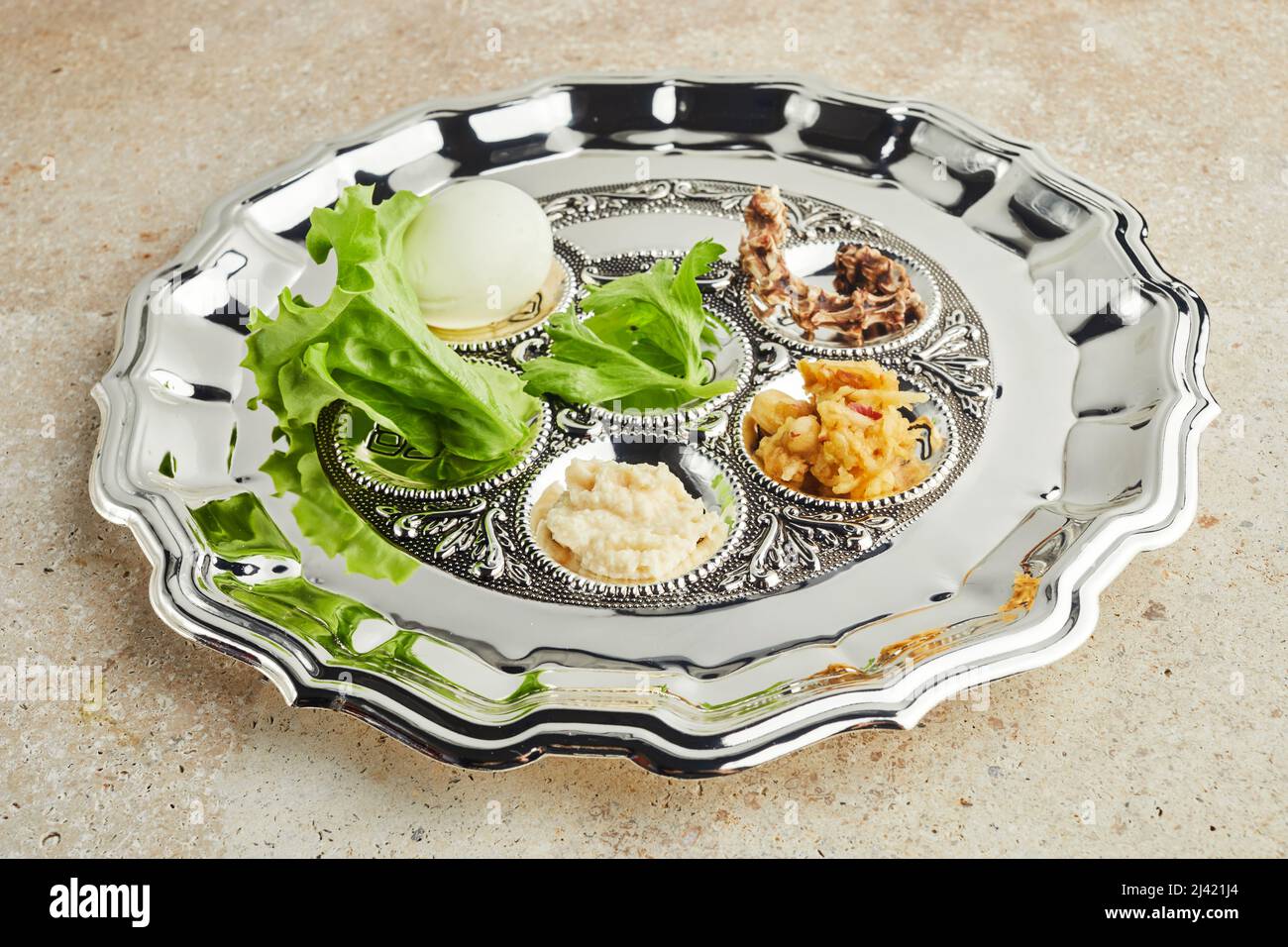 Passover Seder Plate con il tradizionale cibo in pietra di travertino sfondo Foto Stock