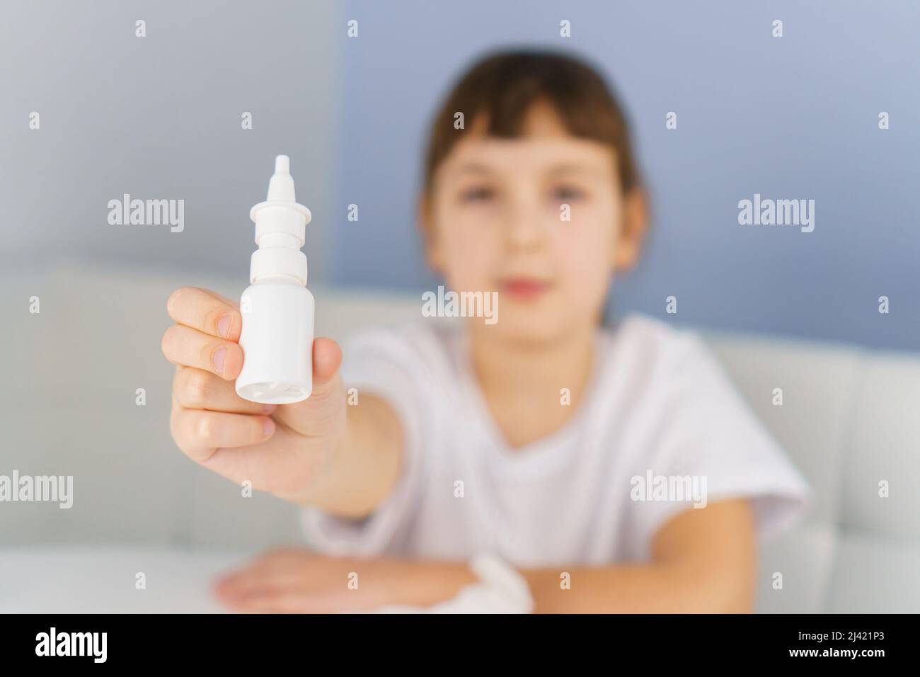Bottiglia di spray nasale in mano di ragazza. Trattamento allergico, rinite virale e batterica e sinusite Foto Stock