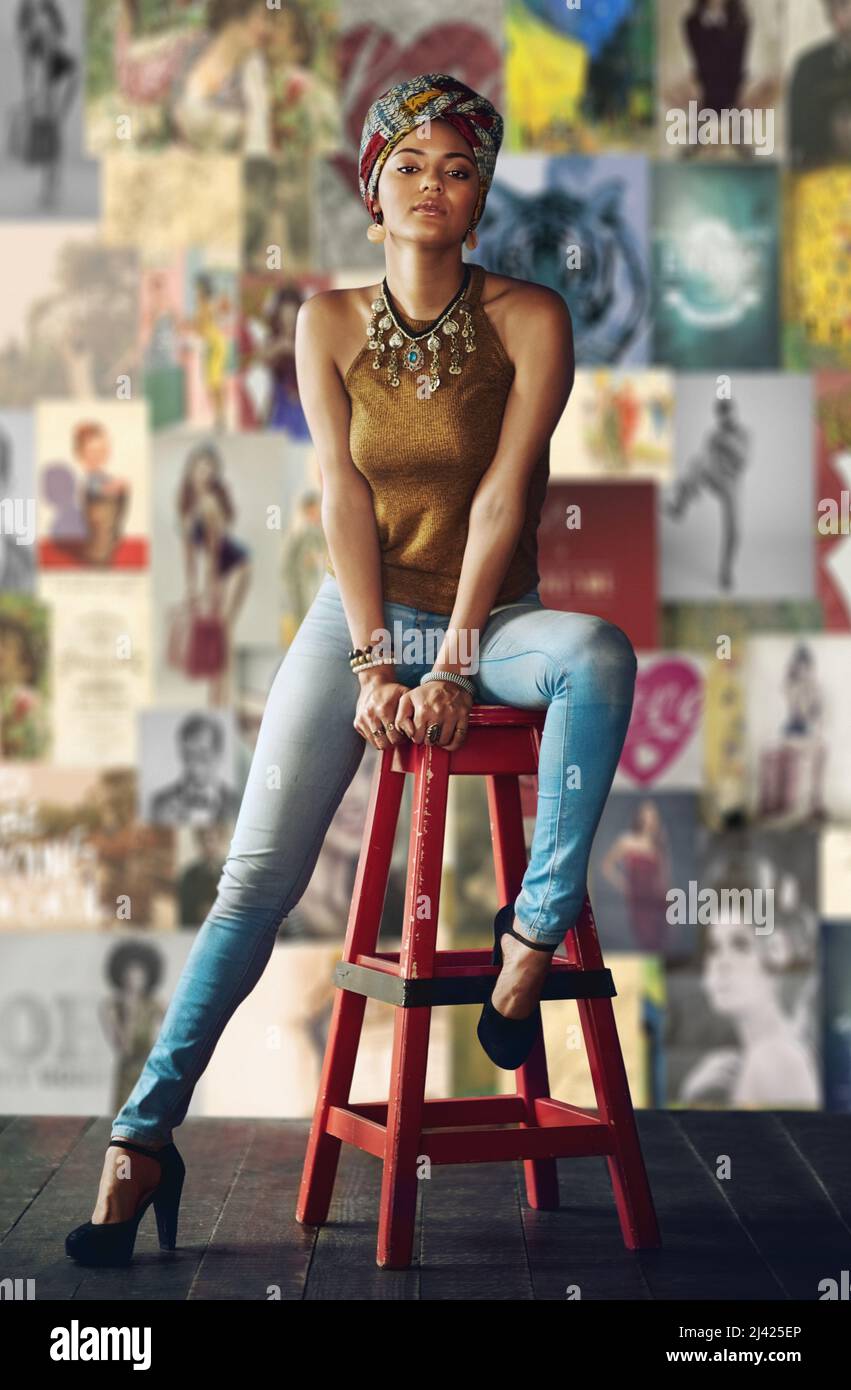 Shes ha ottenuto lo stile. Ritratto completo di una giovane donna sedente su uno sgabello. Foto Stock