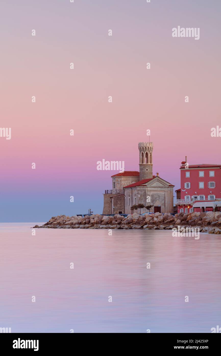 Piran, Slovenia. Immagine del paesaggio urbano di Pirano, Slovenia con chiesa storica e faro all'alba. Foto Stock