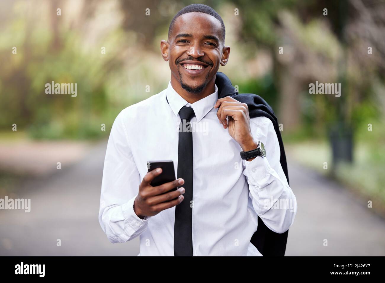 Niente come un po' di aria fresca per liberare la mente. Scatto di un giovane uomo d'affari che usa un telefono in città. Foto Stock