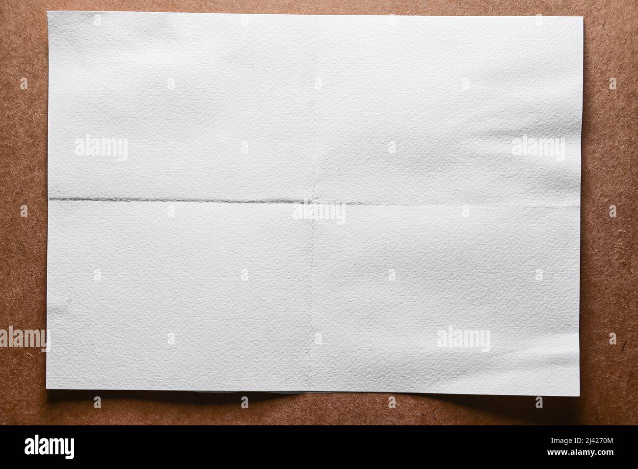 foglio di carta piegato vuoto bianco su sfondo marrone Foto Stock