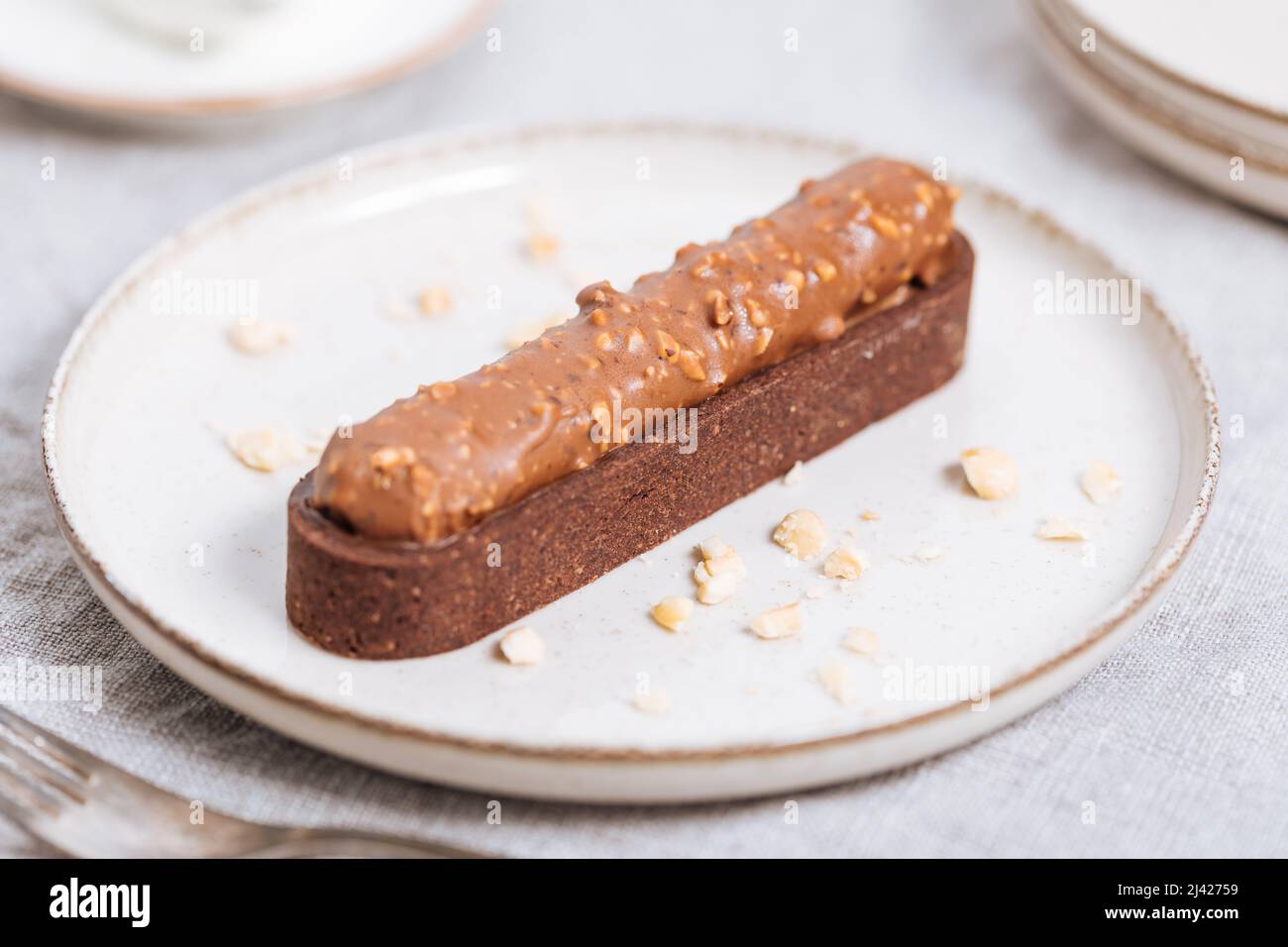 Torta al cioccolato con briciole di nocciole decorata su sfondo chiaro. Foto Stock