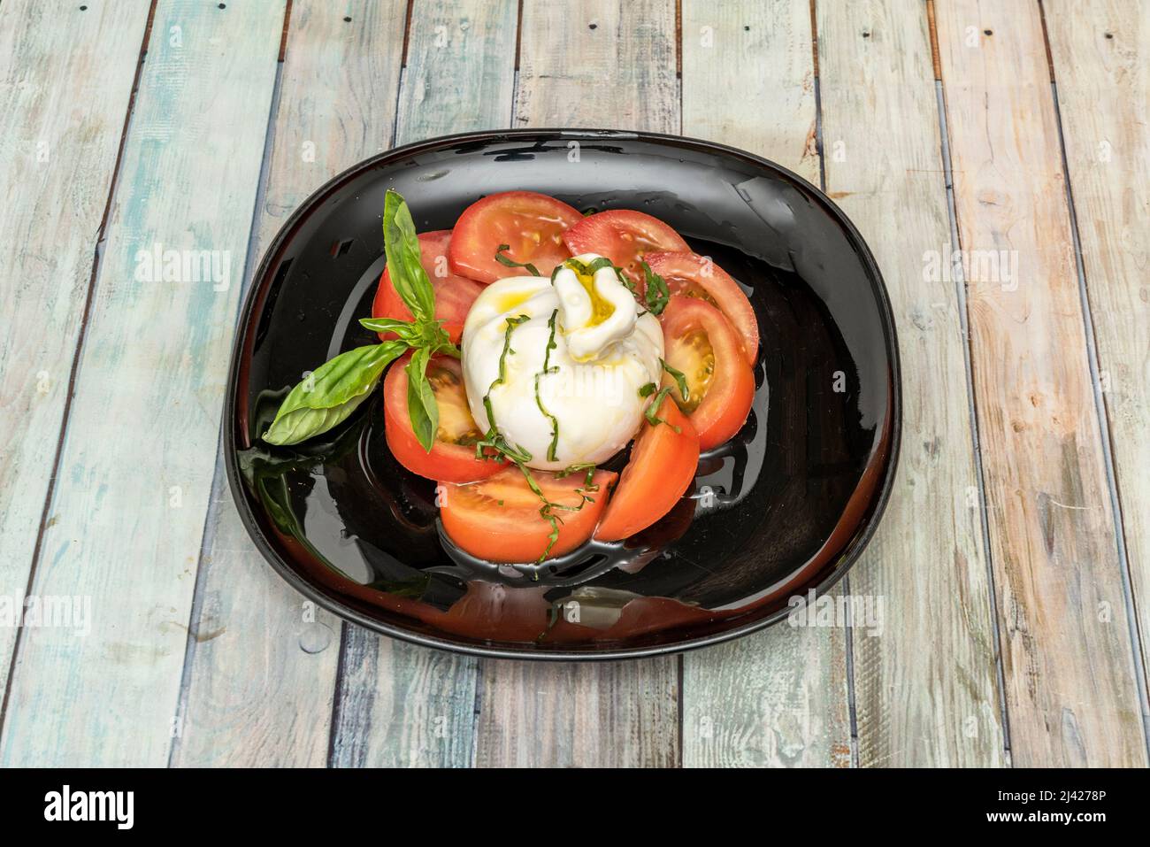 La burrata va bene con la maggior parte dei prodotti, e si può combinare tagliando i pezzi esterni di mozzarella e aggiungendoli a insalate o piatti di pasta. Foto Stock