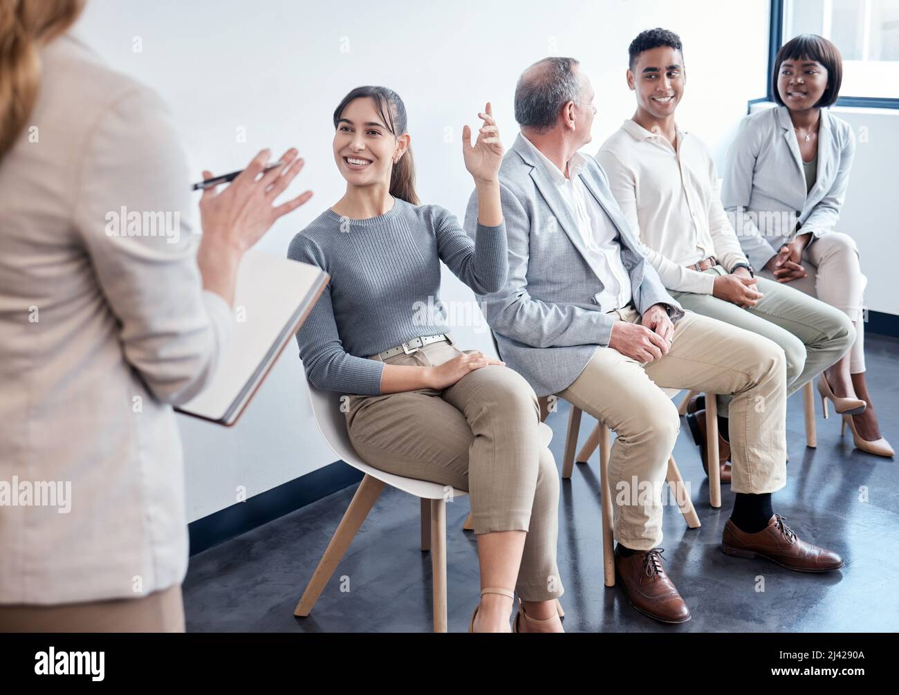 Alzate la mano quando sentite il vostro nome. Shot di un gruppo di nuovi dipendenti che hanno una discussione con il recruiter in un ufficio. Foto Stock