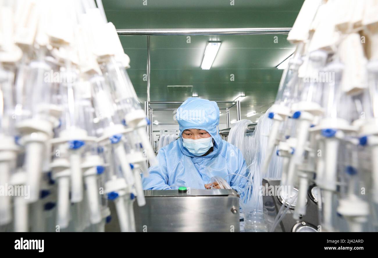 HUAI'AN, CINA - 11 APRILE 2022 - i lavoratori trattano i dispositivi di infusione medica in un workshop a Huai 'an, provincia di Jiangsu, Cina, 11 aprile 2022. Foto Stock