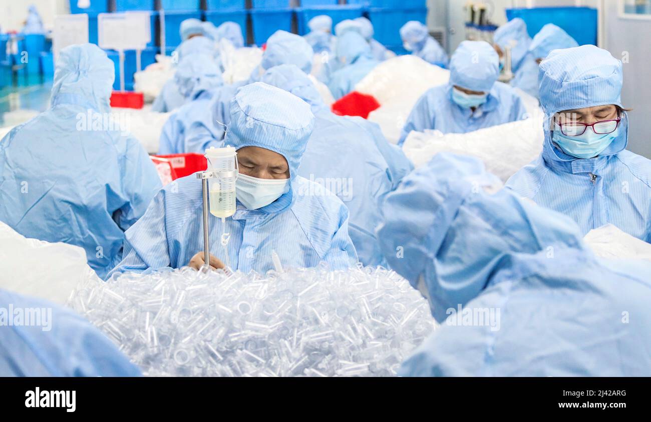 HUAI'AN, CINA - 11 APRILE 2022 - i lavoratori trattano i dispositivi di infusione medica in un workshop a Huai 'an, provincia di Jiangsu, Cina, 11 aprile 2022. Foto Stock