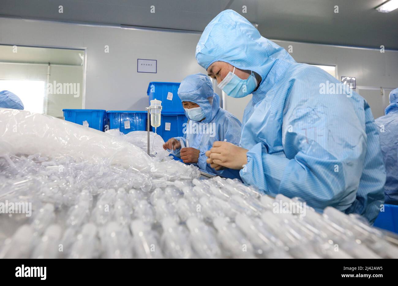 HUAI'AN, CINA - 11 APRILE 2022 - i lavoratori trattano i dispositivi di infusione medica in un workshop a Huai 'an, provincia di Jiangsu, Cina, 11 aprile 2022. Foto Stock