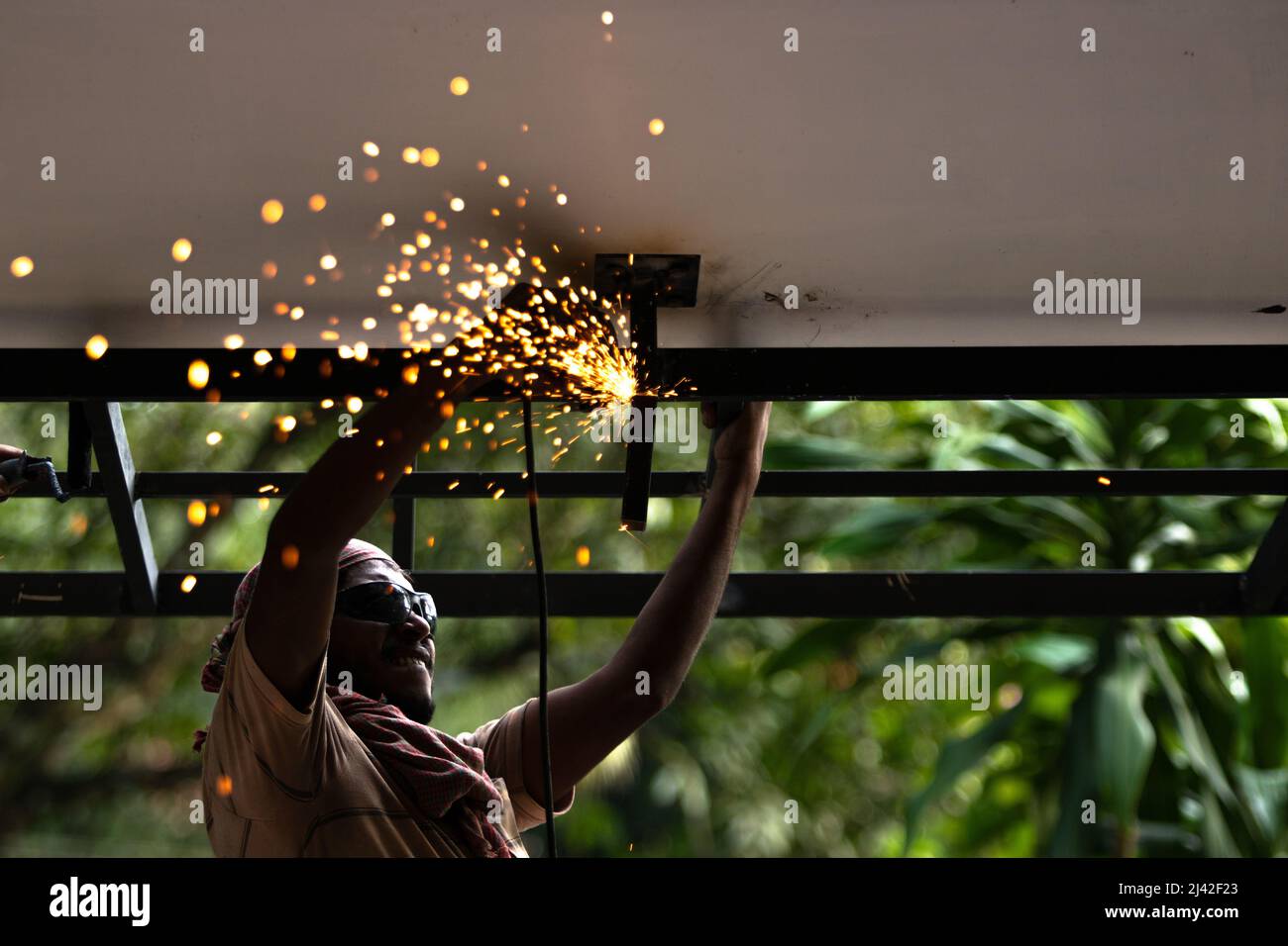 un uomo che fa lavori di saldatura sul tetto Foto Stock