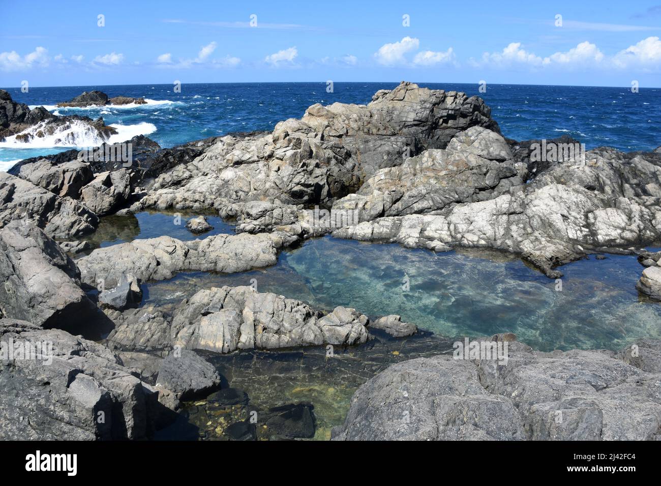 Tranquilla piscina naturale poco profonda lungo la costa della panoramica costa di Aruba. Foto Stock