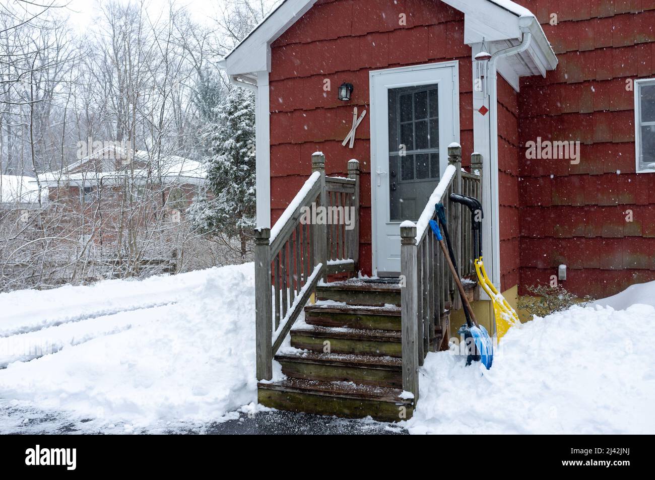 casa suburbana rossa nella tempesta di neve Foto Stock