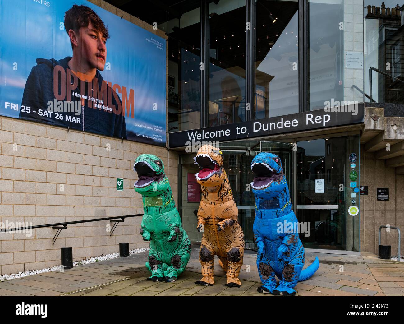 Attori vestiti in bizzarri costumi dinosauri per il lancio del gioco ottimismo al di fuori del Dundee Rep Theatre, Scozia, Regno Unito Foto Stock