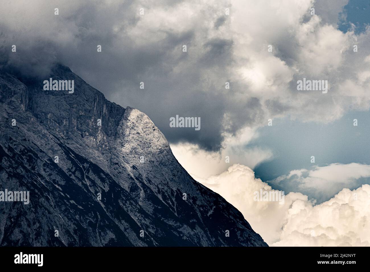 I Thundernubi iniziano a coprire un fianco di montagna in un improvviso cambiamento climatico nelle Alpi tirolesi Foto Stock