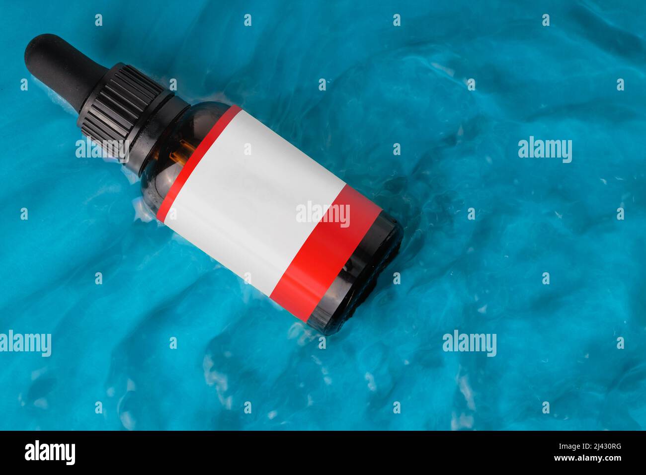 Cosmetici in bottiglia in acqua, concetto di idratazione della pelle. Acido ialuronico. VISTA DALL'ALTO, etichetta vuota. Foto Stock