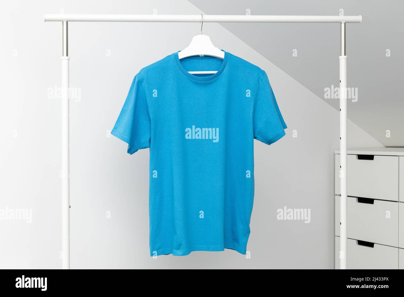 T-shirt appesa al portabiti. Colore blu collo rotondo. Modello, mock up Foto Stock