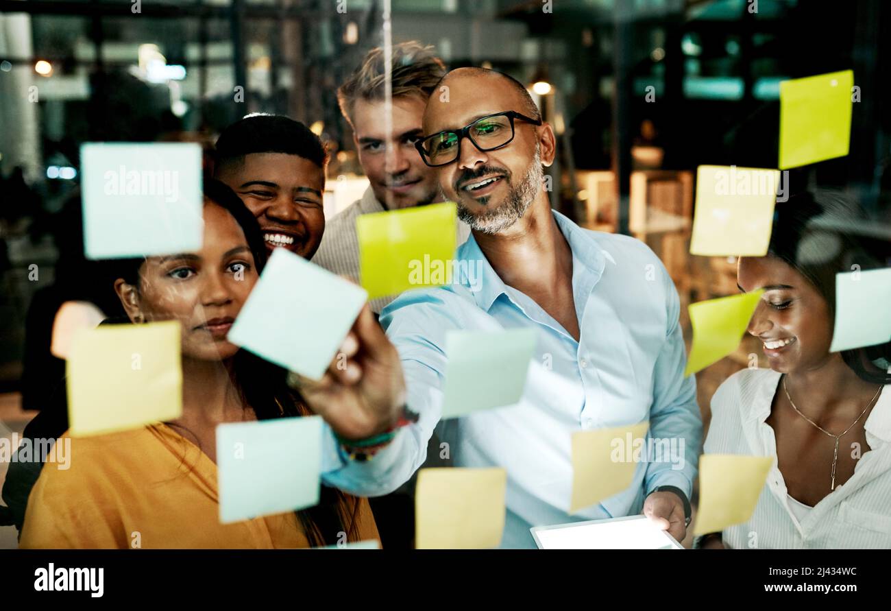 Trasformare il business in una macchina di marketing. Shot di un gruppo di uomini d'affari che hanno una sessione di brainstorming a tarda notte in un ufficio moderno. Foto Stock