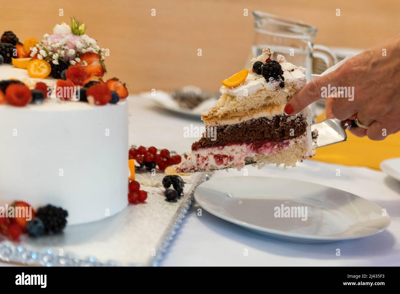 Donna che serve dolce torta con frutta Foto Stock