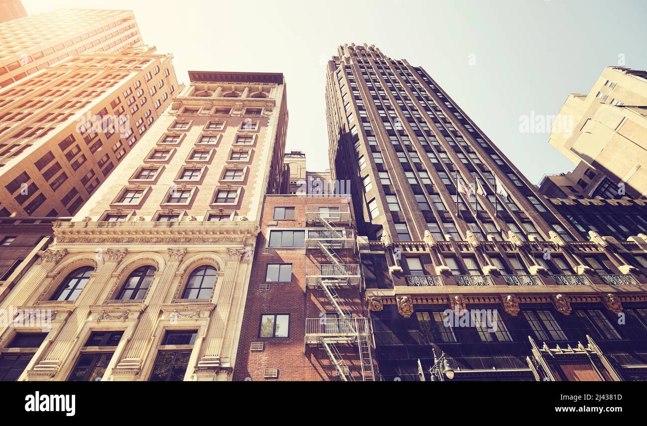 Guardando in alto i vecchi edifici di Manhattan contro il sole, foto dai colori tonici, New York City, USA. Foto Stock