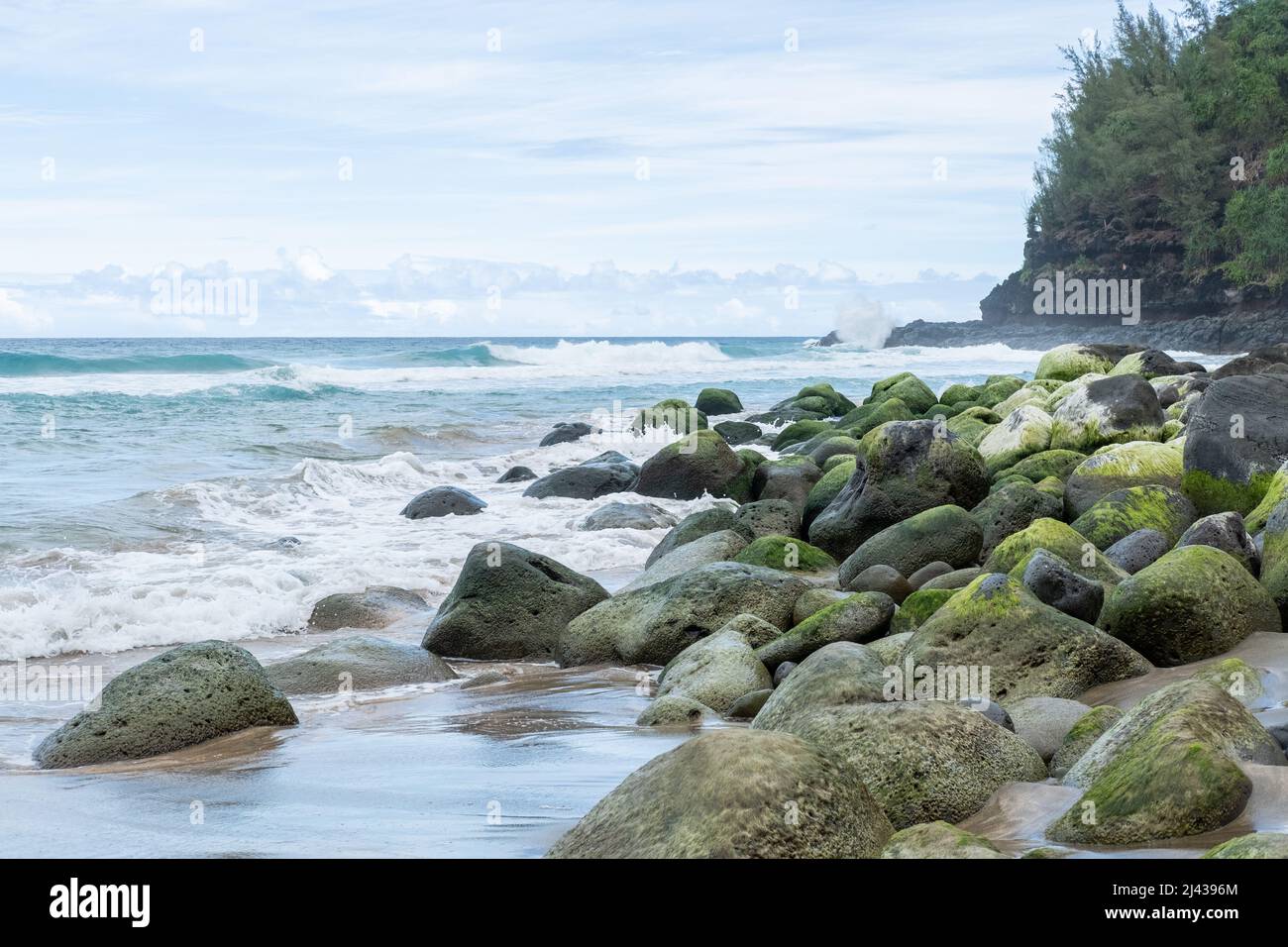 Pietre verdi su una spiaggia in Kauai, Hawaii Foto Stock