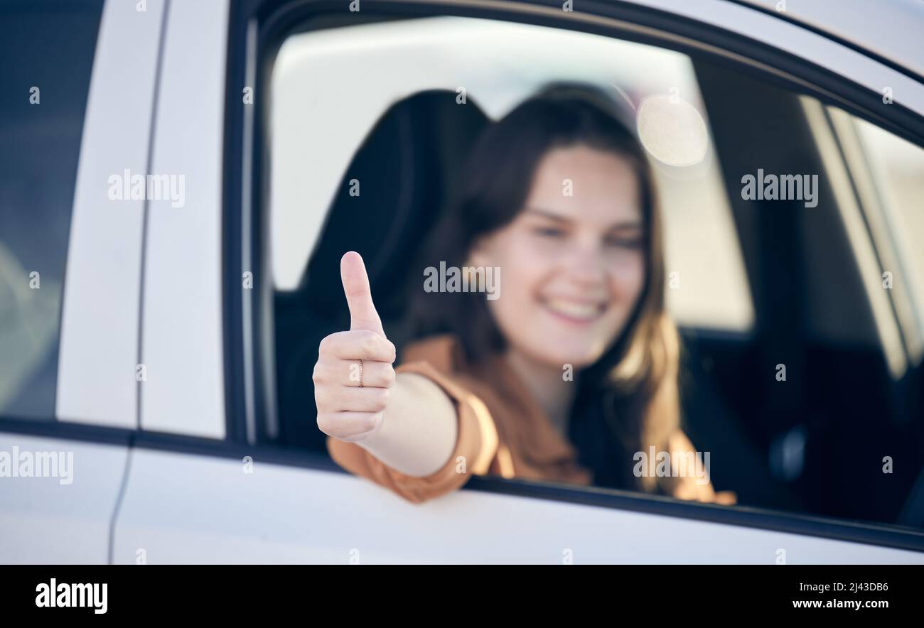 Un'espressione dei miei sentimenti interiori. Scatto di una femmina che mostra i pollici in su mentre siitng in un'automobile. Foto Stock