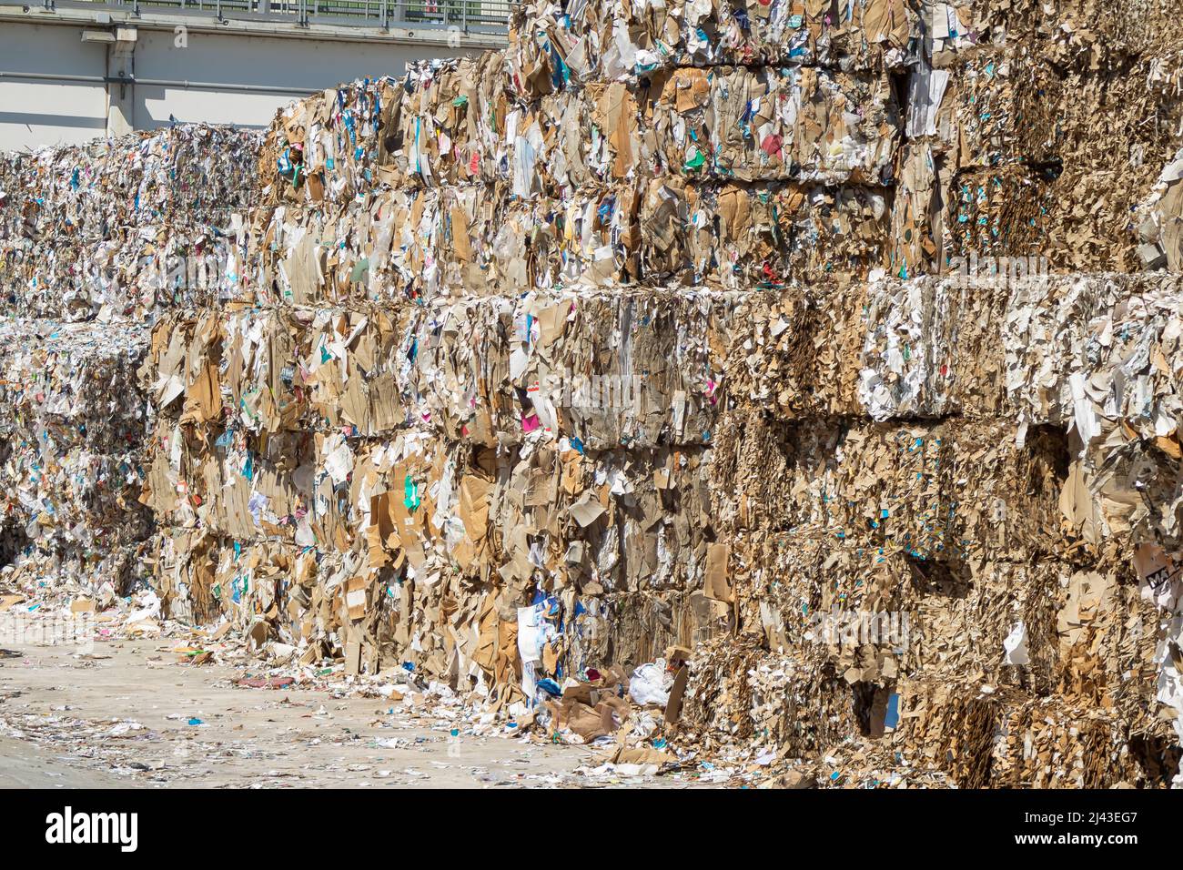 carta riciclata impilata in un impianto di riciclaggio industriale. Foto Stock