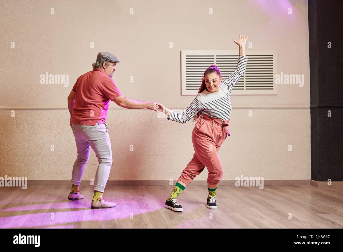 Un paio di ballerini senior lindy hop indossando dei calzini divertenti Foto Stock