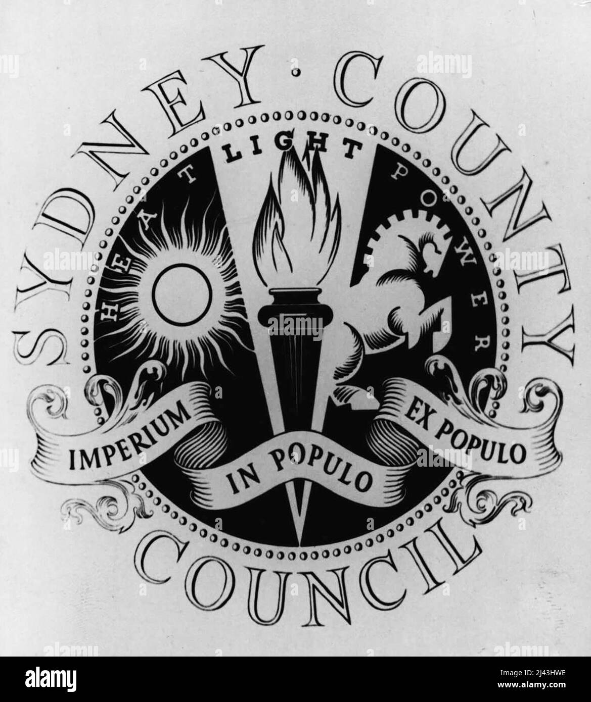 Badge scelto: Per il Consiglio della contea -- da 179 disegni presentati per il suo distintivo, il Consiglio della contea di Sydney al giorno deciso su quello inviato da Miss 'Bonny Ribons,' del Centennial Park, Sydney. Il partecipante di successo riceverà il premio di £25. Il motto sul badge è "Imperium in Populo ex-Populo", che viene tradotto come "potere della gente di dare il potere della gente". Il disegno è simbolico della funzione dell'impresa elettrica nel fornire calore, luce e potere, che sono repressen Foto Stock