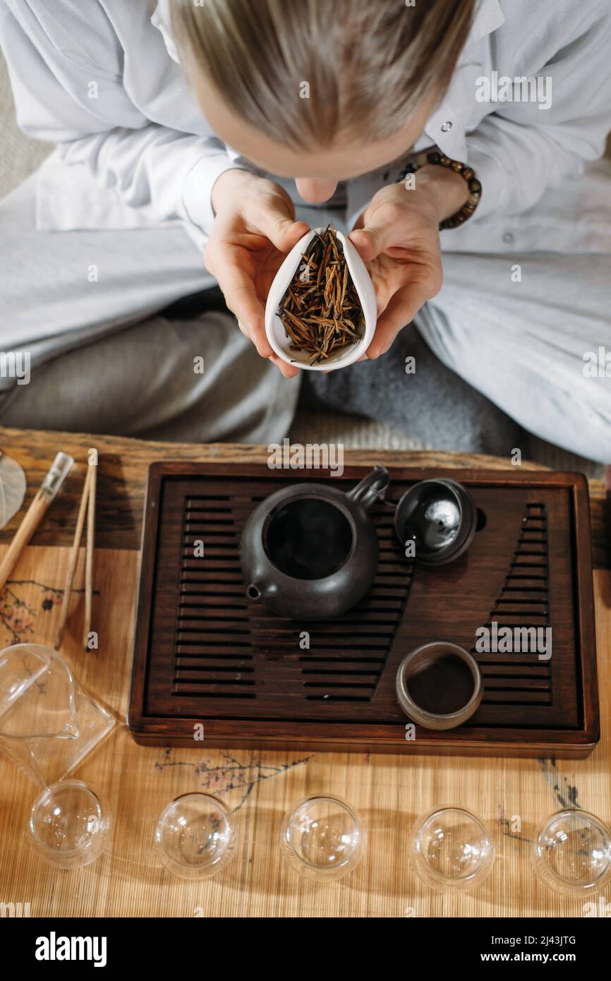 Serve tradizionale cerimonia del tè cinese e versare oolong da una teiera con vapore su sfondo scuro Foto Stock