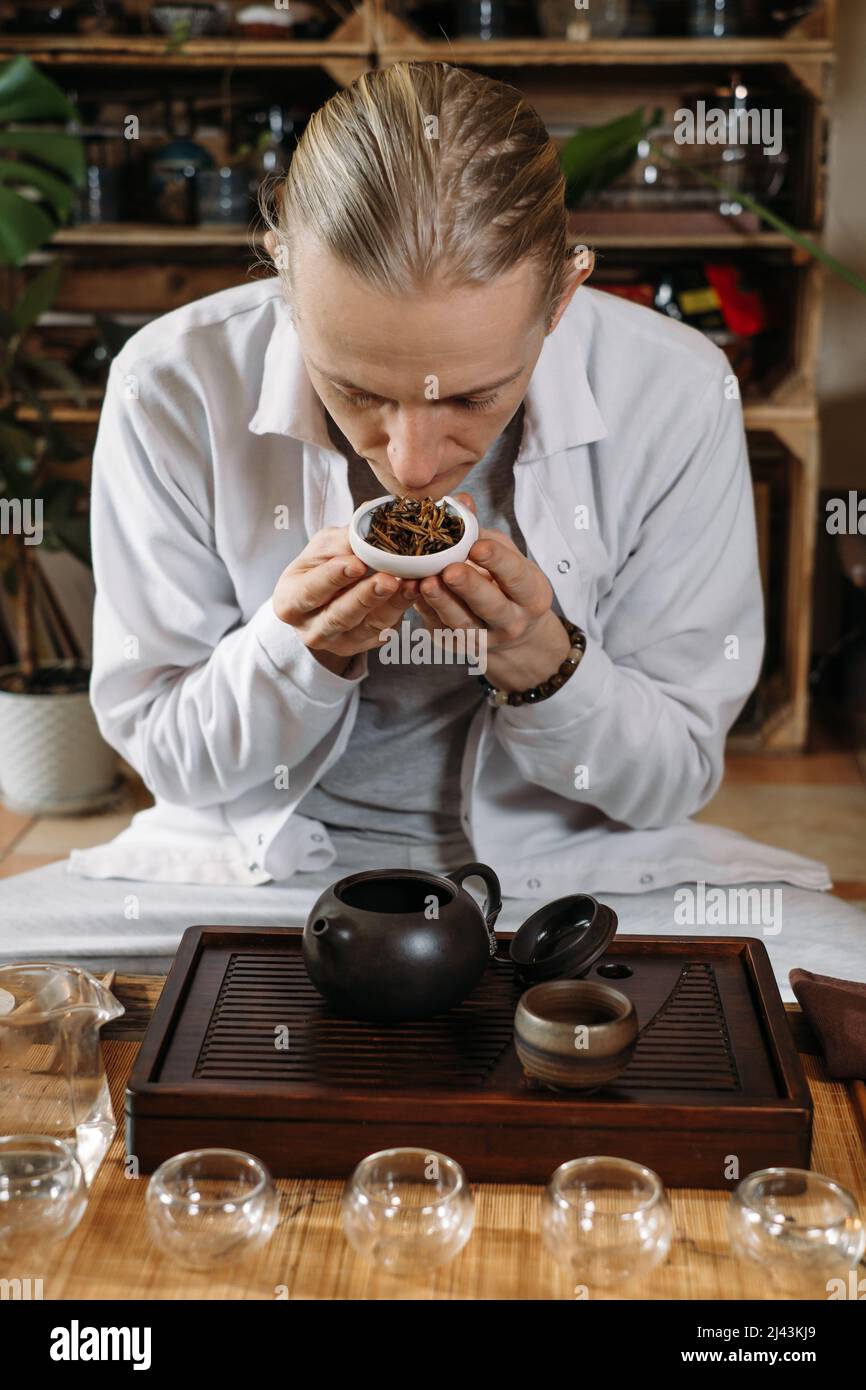 Serve tradizionale cerimonia del tè cinese e versare oolong da una teiera con vapore su sfondo scuro Foto Stock