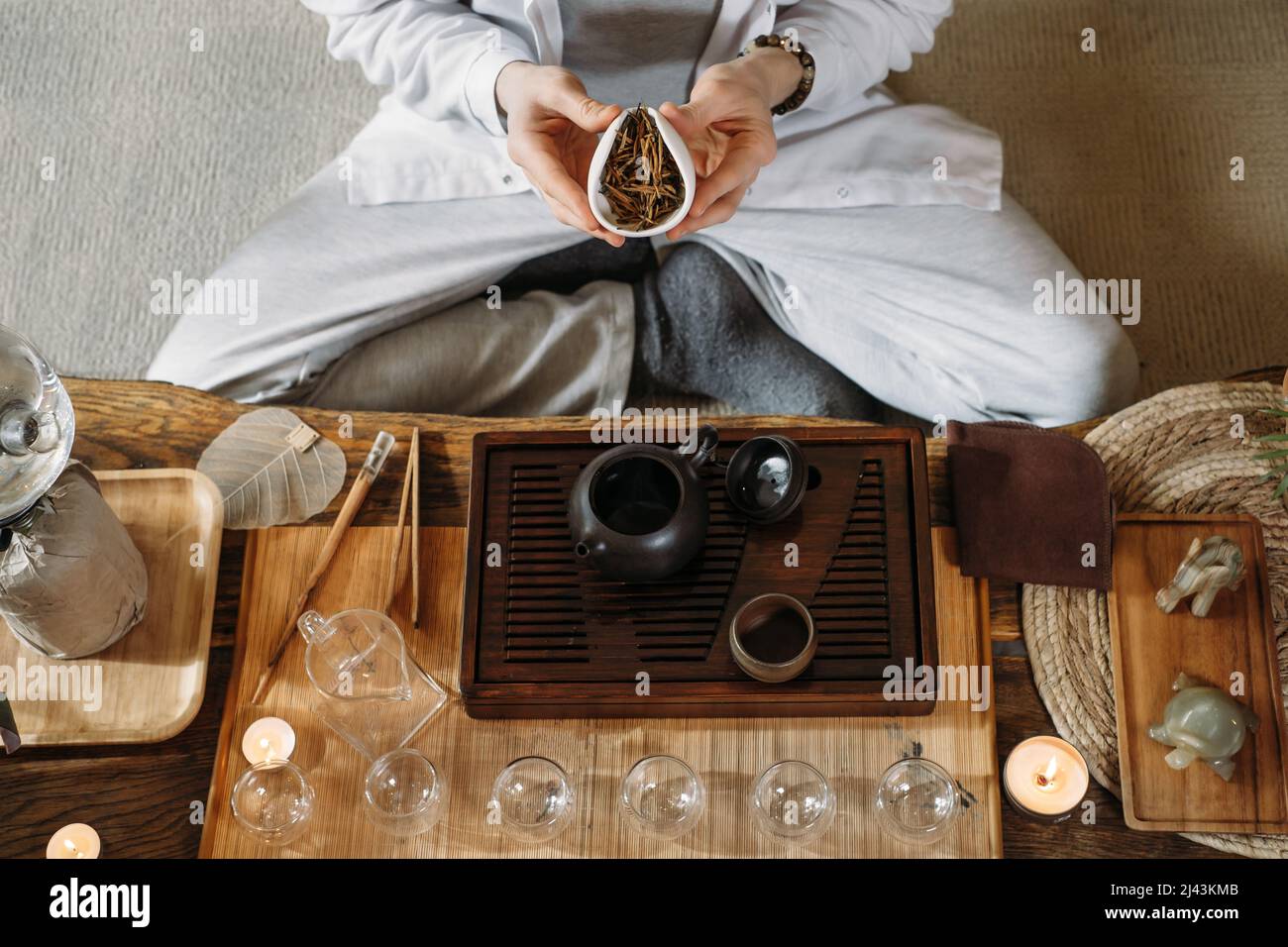 Serve tradizionale cerimonia del tè cinese e versare oolong da una teiera con vapore su sfondo scuro Foto Stock